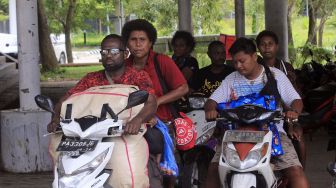 Warga Negara Papua Nugini menumpang ojek sepeda motor untuk berniaga di Pasar Skouw, Distrik Muara Tami, Kota Jayapura, Papua, Sabtu (27/8/2022).  ANTARA FOTO/Gusti Tanati