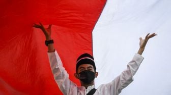 Peserta membentangkan Bendera Merah Putih di kawasan Thamrin, Jakarta, Minggu (28/8/2022). ANTARA FOTO/M Risyal Hidayat