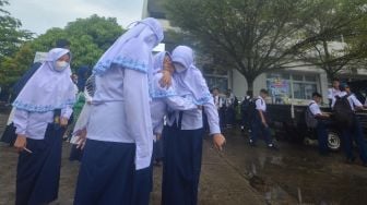 Sejumlah siswa SMP Pembangunan Laboratorium UNP berada di luar bangunan usai terjadi gempa di Padang, Sumatera Barat, Senin (29/8/2022). 
