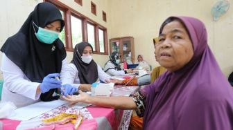 Petugas kesehatan memeriksa kesehatan dari seorang warga lanjut usia (lansia) di Posyandu Ayeum Mata, Desa Alue Raya, Samatiga, Aceh Barat, Aceh, Rabu (31/8/2022). [ANTARA FOTO/Syifa Yulinnas/wsj]