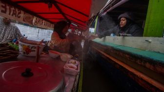 Seorang pengunjung membeli makanan dari pedagang pasar terapung di wisata Pasar Terapung Lok Baintan, Kabupaten Banjar, Kalimantan Selatan, Rabu (31/8/2022). [ANTARA FOTO/Bayu Pratama S/wsj]