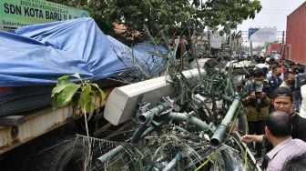 Warga melihat lokasi tempat kejadian kecelakaan sebuah truk kontainer yang menabrak halte bus di depan SDN Kota Baru II dan III di Jalan Sultan Agung, Bekasi, Jawa Barat, Rabu (31/8/2022). [ANTARA FOTO/Fakhri Hermansyah/wsj] 