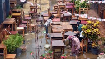 Sejumlah guru dan pegawai sekolah membersihkan meja dan kursi yang basah pasca banjir di SMK Nusantara, Kota Bogor, Jawa Barat, Rabu (31/8/2022). [ANTARA FOTO/Arif Firmansyah/aww]
