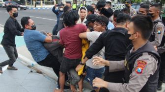 Polisi berusaha menghalau sejumlah mahasisiswa yang akan membakar ban bekas saat berunjukrasa di depan gedung DPRD Kabupaten Jombang, Jawa Timur, Kamis (1/9/2022).  ANTARA FOTO/Syaiful Arif