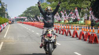 Peserta balap motor berselebrasi usai menang dalam kegiatan Street Race Polda Metro Jaya di Jalan Benyamin Sueb, Kemayoran, Jakarta Pusat, Sabtu (3/9/2022). ANTARA FOTO/Galih Pradipta
