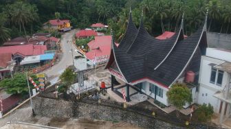 Warga melintas di depan tugu fotokopi di Kantor Wali Nagari Atar, Kabupaten Tanah Datar, Sumatera Barat, Sabtu (3/9/2022). ANTARA FOTO/Iggoy el Fitra