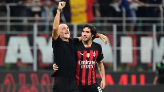 Pelatih AC Milan Stefano Pioli dan gelandang AC Milan Sandro Tonali merayakan kemenangan saat pertandingan sepak bola Serie A Liga Italia antara AC Milan dan Inter Milan di stadion San Siro, Milan, Italia, Sabtu (3/9/2022). [Isabella BONOTTO / AFP]
