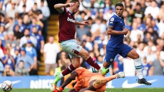 Striker West Ham United Jarrod Bowen (atas) melakukan pelanggaran terhadap kiper Chelsea Edouard Mendy (bawah) saat pertandingan sepak bola Liga Premier Inggris antara Chelsea dan West Ham United di Stamford Bridge, London, Inggris, Sabtu (3/9/2022). [ADRIAN DENNIS / AFP]
