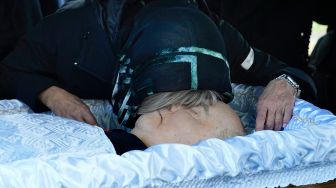 utri Mikhail Gorbachev Irina Virganskaya menangis diatas jenazah ayahnya saat prosesi pemakaman di Pemakaman Novodevichy, Moskow, Rusia Sabtu (3/9/2022). [Alexander ZEMLIANICHENKO / POOL / AFP]
