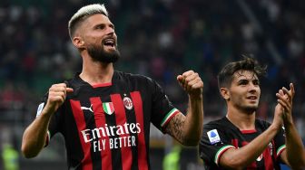 Pemain depan AC Milan Olivier Giroud (kiri) dan gelandang AC Milan Brahim Diaz merayakan kemenangan usai pertandingan sepak bola Serie A Liga Italia antara AC Milan dan Inter Milan di stadion San Siro, Milan, Italia, Sabtu (3/9/2022). [Isabella BONOTTO / AFP]
