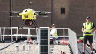 Drone dari perusahaan Helicus membawa sampel jaringan manusia di atas area perkotaan saat uji coba di rumah sakit Network Antwerp (ZNA) di Antwerp, Belgia, Selasa (23/8/2022). [Kenzo TRIBOUILLARD / AFP]