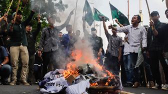 Massa Mahasiswa membakar miniatur keranda saat aksi unjuk rasa menolak kenaikan harga BBM di kawasan Silang Monas, Jakarta Pusat, Senin (5/9/2022). [Suara.com/Alfian Winanto]