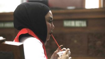 Medina Zein menyeruput minuman saat menjalani sidang di Pengadilan Negeri Jakarta Selatan, Senin (5/9/2022). [Suara.com/Oke Atmaja]