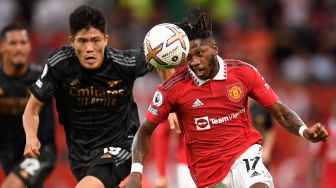 Gelandang Manchester United Fred (kanan) bersaing dengan bek Arsenal Takehiro Tomiyasu (kiri) saat pertandingan sepak bola Liga Premier Inggris antara Manchester United dan Arsenal di Stadion Old Trafford, Manchester, Inggris, Minggu (4/9/2022). [Oli SCARFF / AFP]