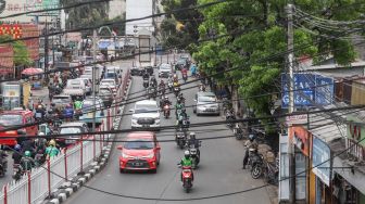 Deretan instalasi kabel yang semrawut di Kramat Jati, Jakarta Timur, Selasa (6/9/2022). [Suara.com/Alfian Winanto]