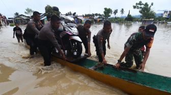 Personel TNI dan Polri mengevakuasi sepeda motor warga yang terendam banjir di Kampung Baru di Palu, Sulawesi Tengah, Selasa (6/9/2022). ANTARA FOTO/Mohamad Hamzah/wsj.