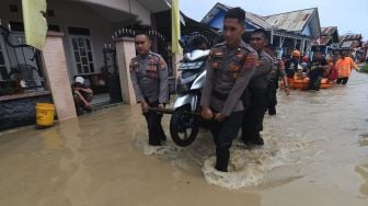 Personel polisi mengevakuasi sepeda motor warga yang terendam banjir di Kampung Baru di Palu, Sulawesi Tengah, Selasa (6/9/2022). ANTARA FOTO/Mohamad Hamzah/wsj.