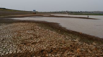 Warga mencari ikan di Waduk Dawuhan yang airnya menyusut di Kabupaten Madiun, Jawa Timur, Selasa (6/9/2022). [ANTARA FOTO/Siswowidodo/tom]
