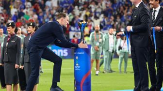 Pelatih Chelsea Thomas Tuchel menyentuh trofi Piala Dunia Klub Antarklub FIFA di atas panggung usai menang melawan Palmeiras dalam laga final di stadion Mohammed Bin Zayed, Abu Dhabi, Uni emirat Arab, Sabtu (12/2/2022). [Giuseppe CACACE / AFP]