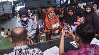 Warga Keluarga Penerima Manfaat (KPM) difoto oleh petugas saat menerima pencairan Bantuan Langsung Tunai (BLT) di Lapang Siliwangi Futsal, Kota Tasikmalaya, Jawa Barat, Kamis (8/9/2022). ANATARA FOTO/Adeng Bustomi/hp.