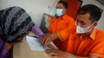 Petugas membantu warga dalam pencairan Bantuan Langsung Tunai (BLT) Bahan Bakar Minyak (BBM) di Kantor Pos Desa Adiwerna, Kabupaten Tegal, Jawa Tengah, Sabtu (10/9/2022). [ANTARA FOTO/Oky Lukmansyah/nym]