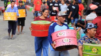 Warga melihat deretan tenong yang berisi nasi tumpeng saat tradisi Tenongan di Desa Malang Semirang, Lobener, Indramayu, Jawa Barat, Sabtu (10/9/2022). [ANTARA FOTO/Dedhez Anggara/nym]