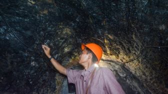 Pengunjung memegang dinding batubara di lubang bekas tambang batubara Mbah Suro di Sawahlunto, Sumatera Barat, Sabtu (10/9/2022). [ANTARA FOTO/Iggoy el Fitra/rwa]