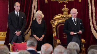 Permaisuri Camilla dan Raja Inggris Charles III tersenyum selama pertemuan Dewan Aksesi untuk menyatakan Charles sebagai Raja baru di dalam Istana St James di London, Inggris, Sabtu (10/9/2022). [Jonathan Brady / POOL / AFP]