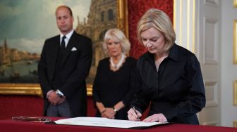 Perdana Menteri Inggris Liz Truss menandatangani Proklamasi Aksesi Raja Charles III saat pertemuan Dewan Aksesi di dalam Istana St James di London, Inggris, Sabtu (10/9/2022). [Kirsty O'Connor / POOL / AFP]