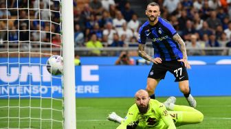 Penjaga gawang Torino Vanja Milinkovic-Savic (kiri) berusaha menghalau bola saat gelandang Inter Milan Marcelo Brozovic (kanan) berusaha mencetak gol saat pertandingan sepak bola Serie A Liga Italia antara Inter Milan dan Torino di stadion San Siro, Milan, Italia, Sabtu (10/9/2022). [Isabella BONOTTO / AFP]