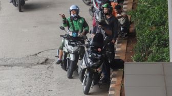 Pengendra Ojek Online melintas di Jalan Gatot Subroto, Jakarta Selatan, Senin (12/9/2022). [Suara.com/Alfian Winanto]