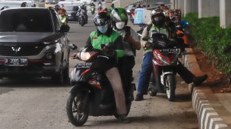 Pengendra Ojek Online melintas di Jalan Gatot Subroto, Jakarta Selatan, Senin (12/9/2022). [Suara.com/Alfian Winanto]