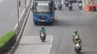 Pengendra Ojek Online melintas di Jalan Gatot Subroto, Jakarta Selatan, Senin (12/9/2022). [Suara.com/Alfian Winanto]