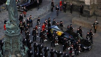 Peti mati mendiang Ratu Elizabeth II yang dibungkus dengan bendera Royal Standard of Scotland, saat tiba di Katedral St Giles di Edinburgh, Skotlandia, Senin (12/9/2022). [RUSSELL CHEYNE / POOL / AFP]