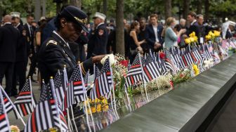 Kolonel Davis meletakkan karangan bunga untuk rekannya Kapten Micheal Dermott Mullan yang tewas saat Peringatan 9/11 di New York, Amerika Serikat, Minggu (11/9/2022). [Yuki IWAMURA / AFP]
