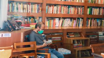 Pengunjung membaca buku di perpustakaan "Baca Di Tebet", Jakarta Selatan, Rabu (14/5/9/2022). [Suara.com/Alfian Winanto]