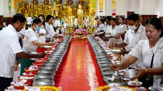 SUmat Buddha makan bersama selama festival Pchum Ben (Festival Kematian) di sebuah pagoda di Phnom Penh, Kamboja, Selasa (13/9/2022). [TANG CHHIN Sothy / AFP]