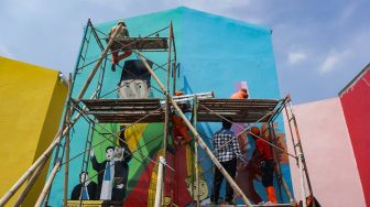 Sejumlah petugas Penanganan Prasarana & Sarana Umum (PPSU) menyelesaikan pembuatan mural di Kampung Gembira Gembrong, Jakarta Timur, Rabu (14/9/2022). [Suara.com/Alfian Winanto]