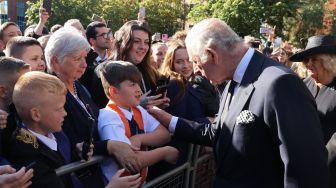 Raja Inggris Charles III menyapa masyarakat saat tiba di Kastil Hillsborough, Belfast, Irlandia Utara, Selasa (13/9/2022). [Niall Carson / POOL / AFP]