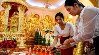 Para wanita membakar dupa saat mereka berdoa selama festival Pchum Ben (Festival Kematian) di sebuah pagoda di Phnom Penh, Kamboja, Selasa (13/9/2022). [TANG CHHIN Sothy / AFP]
