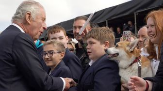 Raja Inggris Charles III menyapa masyarakat saat tiba di Kastil Hillsborough, Belfast, Irlandia Utara, Selasa (13/9/2022). [Niall Carson / POOL / AFP]