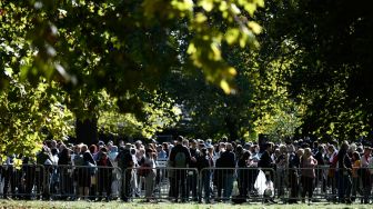 Masyarakat mengantri di Southwark Park untuk memberi penghormatan kepada mendiang Ratu Elizabeth II yang terbaring di Westminster Hall, London, Inggris, Sabtu (17/9/2022). [STEPHANE DE SAKUTIN / AFP]