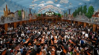 Suasana di tenda bir saat acara festival bir Oktoberfest di lapangan pameran Theresienwiese di Munich, Jerman, Sabtu (17/9/2022). [Christof STACHE / AFP]
