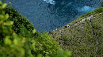 Wisatawan mengunjungi Pantai Kelingking, Nusa Penida, Klungkung, Bali, Sabtu (17/9/2022). [ANTARA FOTO/Fikri Yusuf/aww]