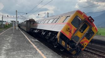 Sebuah kereta api tergelincir akibat gempa bumi di Stasiun Dongli, Hualien, Taiwan, Minggu (18/9/2022). [Handout / National Fire Agency / AFP]