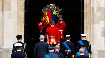 Prajurit kerajaan membawa peti mati Ratu Elizabeth II saat prosesi pemakaman di Kapel St George yang ada di dalam Kastil Windsor, Inggris, Senin (19/9/2022). [Jeff J Mitchell / POOL / AFP]