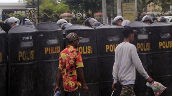 Sejumlah polisi bersiaga saat massa pendukung Gubernur Papua Lukas Enembe berunjuk rasa menolak penetapan tersangka Gubernur Papua Lukas Enembe oleh Komisi Pemberantasan Korupsi (KPK) di Titik Nol, Taman Imbi, Kota Jayapura, Papua, Selasa (20/9/2022). [ANTARA FOTO/Gusti Tanati/app/foc].