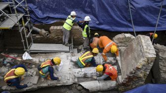 Sejumlah pekerja berusaha membersihkan terakota berupa saluran air yang berada di proyek pembangunan jalur MRT Jakarta fase 2 CP-203 di kawasan Glodok, Jakarta Barat, Selasa (20/9/2022).[ANTARA FOTO/M Risyal Hidayat/foc].