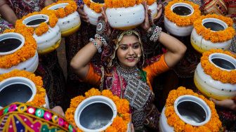Peserta dari kelompok seni mengenakan pakaian tradisional berlatih tari Garba menjelang festival Navratri di Ahmedabad, India, Selasa (20/9/2022). [SAM PANTHAKY / AFP]
