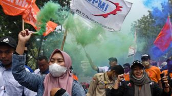 Buruh membawa kembang api asap saat berunjuk rasa di depan Balai Kota DKI Jakarta, Jakarta, Rabu (21/9/2022). [ANTARA FOTO/Aditya Pradana Putra/nz].